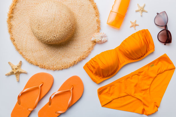 女子泳装和海滩配件平铺顶视彩色背景夏季旅行的概念。比基尼泳装，草帽和高跟鞋。复制空间俯视图图片下载