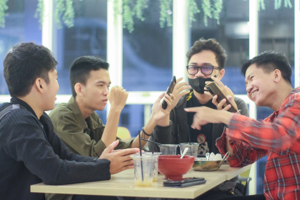 一群年轻人在咖啡馆里打电话聊天图片下载