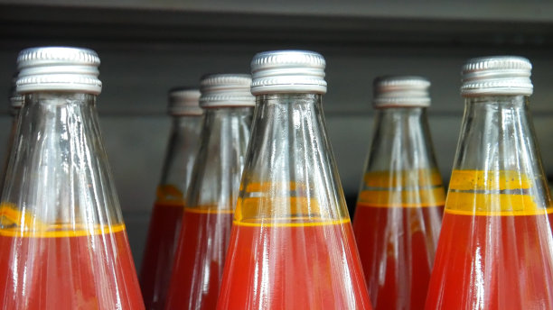 商店货架上许多装有沙棘汁的玻璃瓶的特写图片下载