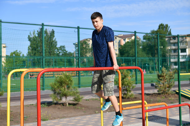 一个十几岁的男孩在户外运动场上训练，他做体育锻炼，健康的生活方式，在一个明媚的夏日图片下载