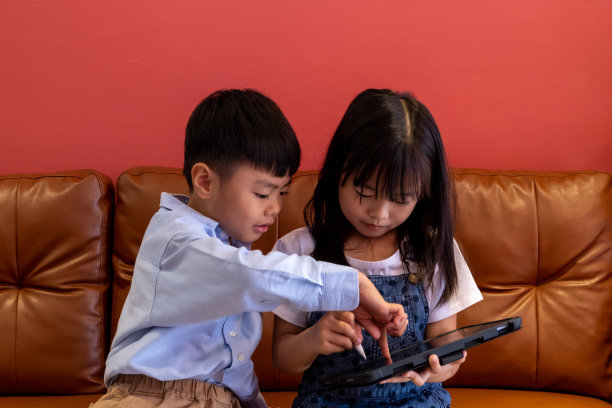 女孩和男孩正在玩电话。图片下载