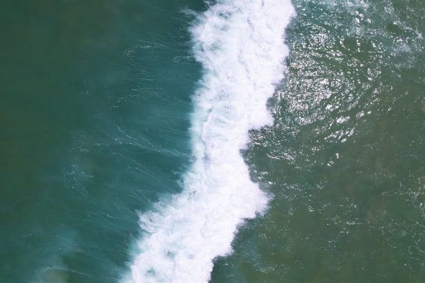 海蓝表面鸟瞰图。俯视蓝色的水，白色的泡沫背景海浪图片下载