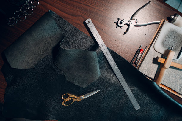 制革女工在车间里制作皮具。皮革工匠的工作过程图片下载