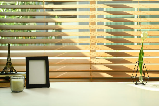 白色的桌子上放着空白的相框、蜡烛、书和花盆。舒适的工作场所。图片下载