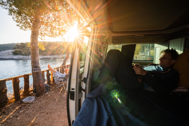 一名男子在露营车里休息时使用笔记本电脑图片下载