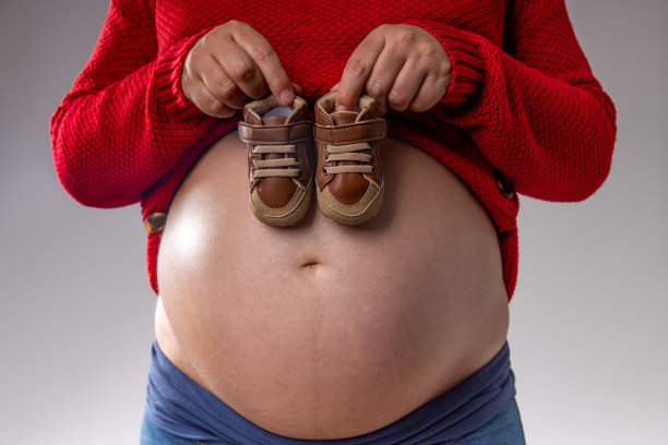 孕妇把婴儿鞋放在肚子上图片下载