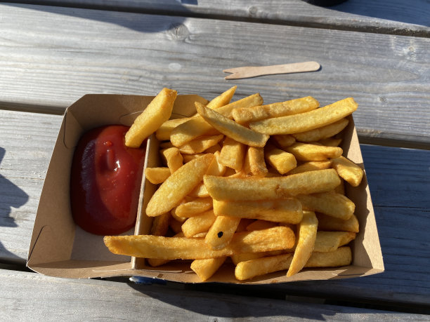 一份装在纸盒里的薯条加番茄酱图片下载