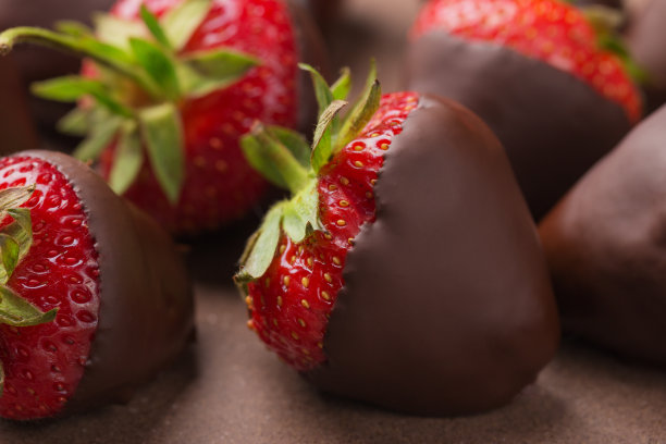黑巧克力覆盖草莓在陶瓷盘子上的特写。美味的食物。甜点的背景。图片下载