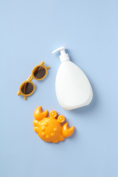 婴儿防晒乳瓶模型，沙模，蓝色背景的太阳镜。平铺，俯视图。图片下载