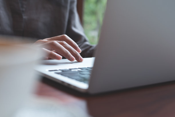 女人在家里的木桌上使用手提电脑，在网上搜索信息，浏览互联网，在任何地方工作图片下载