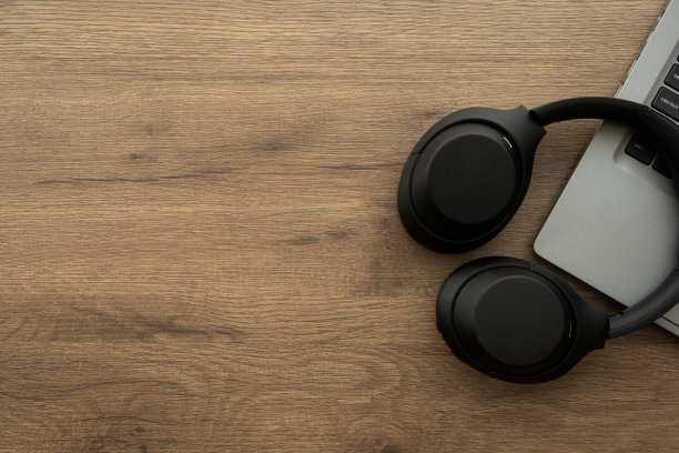 木质办公桌，配有笔记本电脑和耳机。俯视图与复制空间，平面布局。图片下载