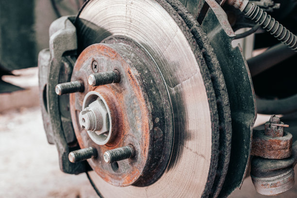 当机械师检查汽车时，生锈的旧刹车盘会得到维修或更换。制动系统的安全性和磨损性图片下载