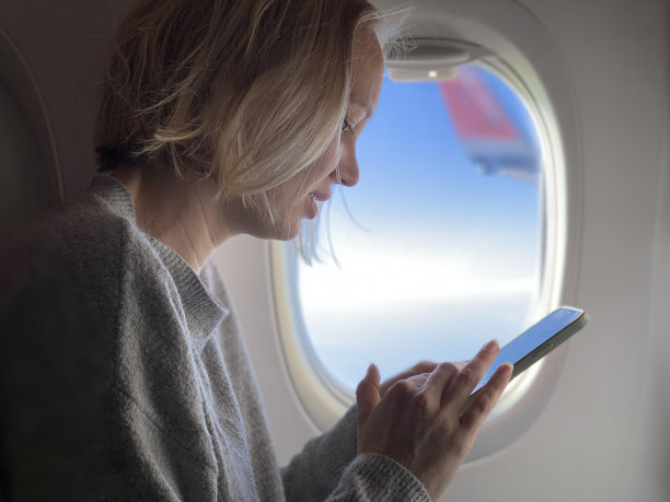 女性在飞机座位上使用智能手机图片下载