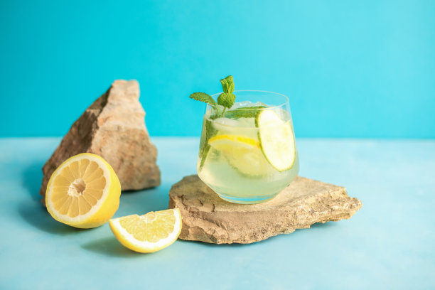 夏季排毒清爽饮料或酒精鸡尾酒加柠檬片和冰，用薄荷枝装饰。冰水加柠檬。健康的饮料。图片下载