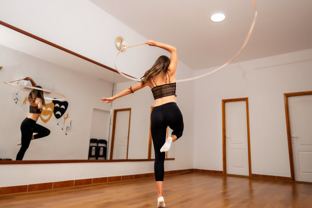 年轻的女舞蹈家在舞蹈工作室练习她的艺术体操彩带舞素材图片
