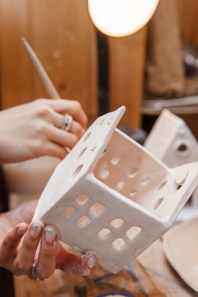 一位陶艺大师手里拿着一件陶土制品。用粘土做一个陶瓷烛台。在烛台上涂釉的过程。图片下载
