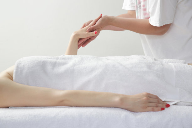 手臂按摩。年轻的白人女性享受软拍摄部分放松按摩体验在水疗沙龙。图片下载