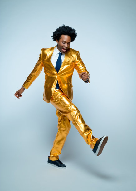 欢快的男人穿着金色的西装跳舞图片下载