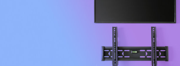 安装在墙上的金属支架，带有气泡水平，用于安装电视或监视器。渐变颜色的照明。在墙上安装一台现代电视或电脑显示器的概念。本空间图片下载