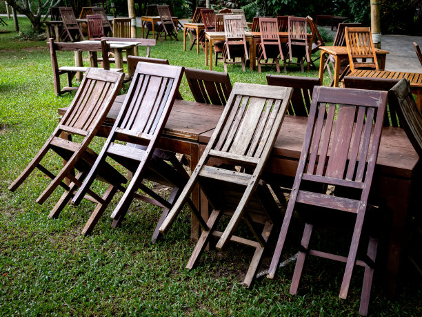 绿色的庭院花园里摆着一张废弃的空木桌。室外餐厅永久关闭，旧餐桌无用。图片下载