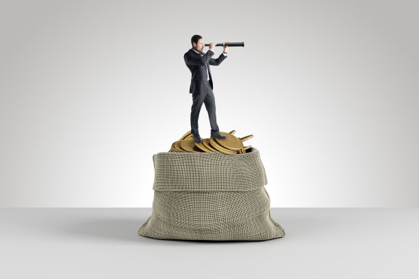 有吸引力的年轻欧洲商人与望远镜站在巨大的袋子装满了金色的硬币在光的背景。财富、财富、市场调研、老板理念。图片下载