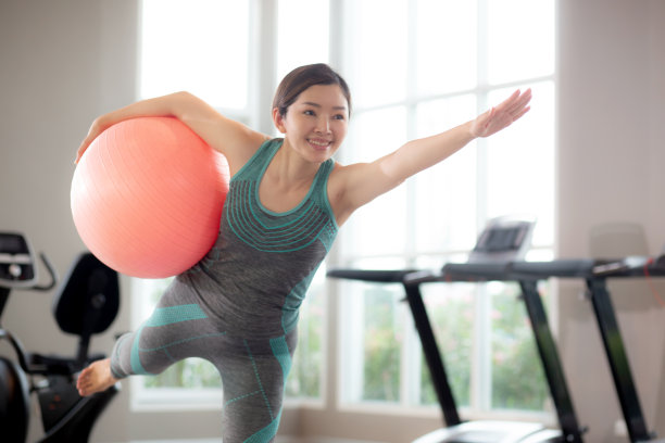 年轻的亚洲女性在健身房做瑜伽或有氧运动，伸展肌肉，手部，女性训练练习锻炼与瑜伽在家里的身体护理，康复与灵活的身体，运动理念。图片下载