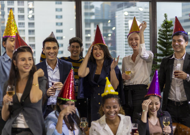 特写微笑的商人在办公室的新年晚会和庆祝新年的小团体。图片下载