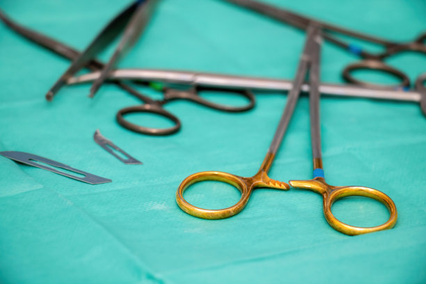 绿色织物背景上的消毒手术器械。外科医生不锈钢工具。图片下载