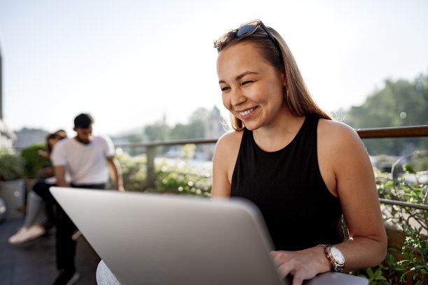 年轻的金发女商人在伊斯坦布尔的露台上使用笔记本电脑工作图片下载