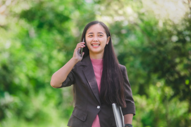 女商人站在小镇旁边的公园里接电话图片下载