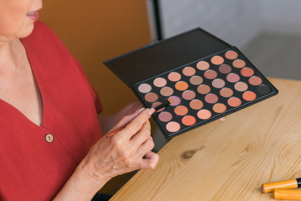 特写的女人拿着化妆刷和腮红和眼影调色板-美和化妆品的概念图片下载