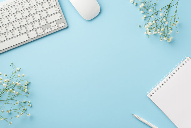 经营理念。俯视图的工作空间的照片，键盘，电脑，鼠标，打开copybook钢笔和白色的石膏花在孤立的粉彩蓝色的背景与copyspace图片下载