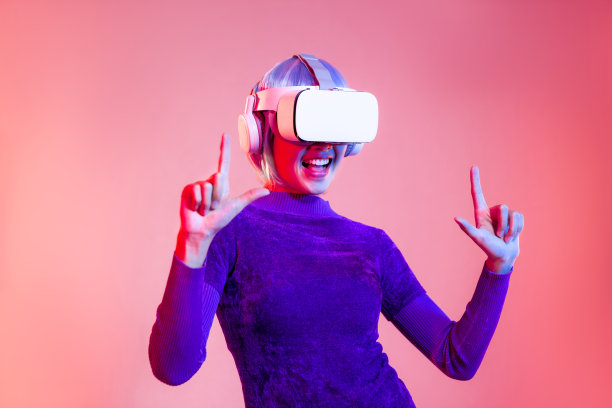 元宇宙概念，年轻的亚洲女性在紫色运动衫赛博朋克发型戴着白色vr耳机手指指向和触摸粉红色霓虹灯背景。“t图片下载