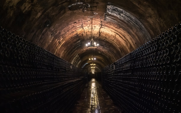 长地下隧道在地窖中储存和陈酿玻璃瓶葡萄酒图片下载