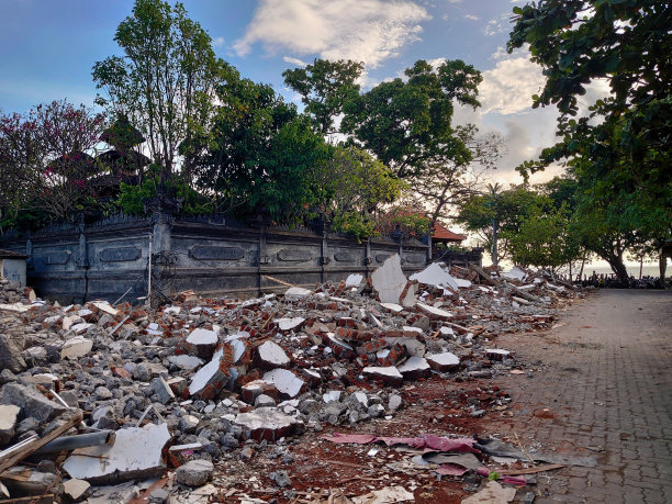 海滩附近被拆毁的建筑物的废墟图片下载