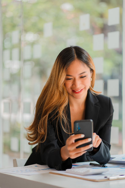 亚洲商界女性在工作中使用电脑女性在办公室开始处理商业计划和报告文件。年轻的企业家用智能手机聊天。官方顾问垂直图图片下载