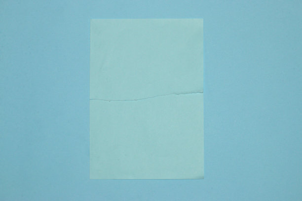 粉彩蓝色纸撕成两半在蓝色背景，创意现代设计，拷贝空间，夏天的概念图片下载