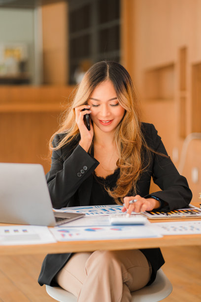 亚洲商界女性在工作中使用电脑女性在办公室开始处理商业计划和报告文件。年轻的企业家用智能手机聊天。官方顾问垂直图图片下载