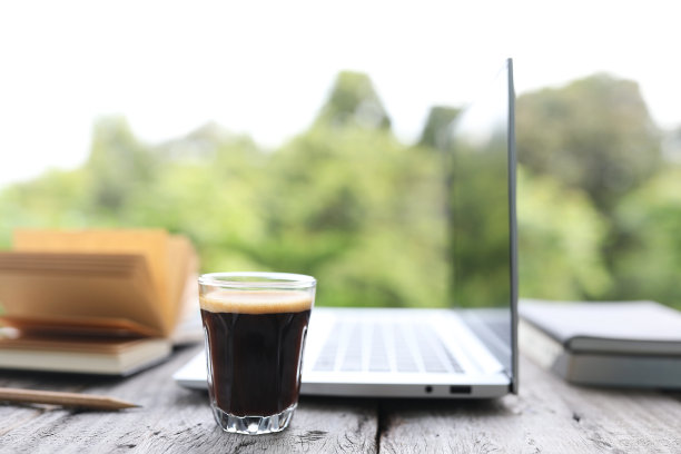 咖啡杯和笔记本电脑在玻璃桌上户外视野图片下载