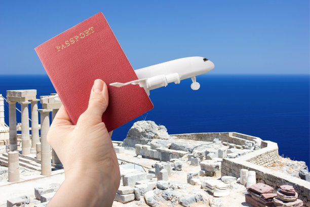 旅行社，旅行，廉价航空旅行，机票预订，手里拿着飞机和护照，背景是希腊卫城的大海和天空图片下载