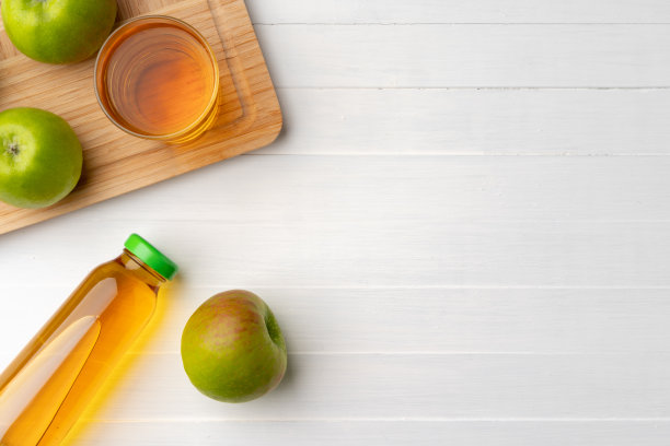 新鲜苹果汁的瓶子在灰色的背景图片下载