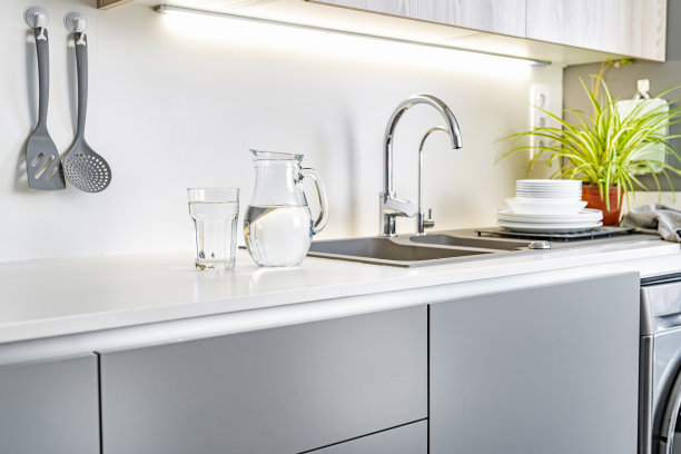 在厨房柜台上放满水的玻璃杯和水罐图片下载