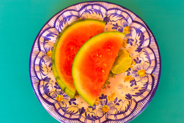 两个西瓜片在蓝色的花盘子图片下载