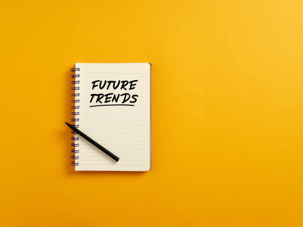 记事本和黑色钢笔在黄色背景与未来的趋势。图片下载