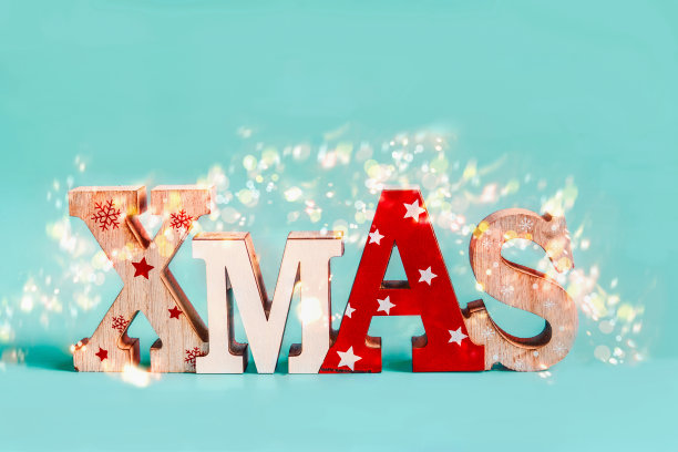 单词圣诞节与假日散景在蓝色背景。圣诞节日的概念。图片下载
