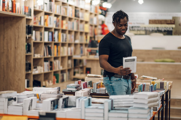在图书馆或书店挑选和阅读书籍的非裔美国人图片下载