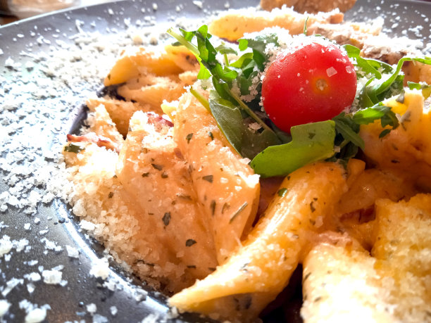 意大利面盘俯视图，樱桃番茄通心粉，沙拉和帕尔马干酪。食物特写照片图片下载