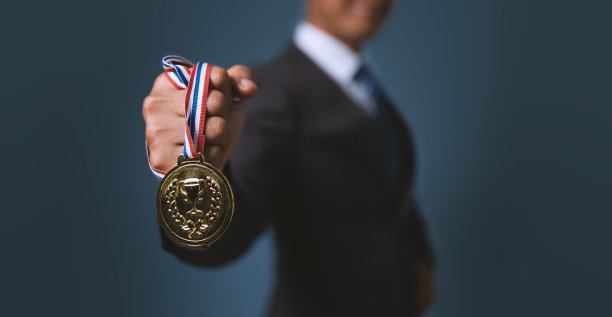 一个拿着金牌的商人。在商业上取得成功，实现商业目标。图片下载