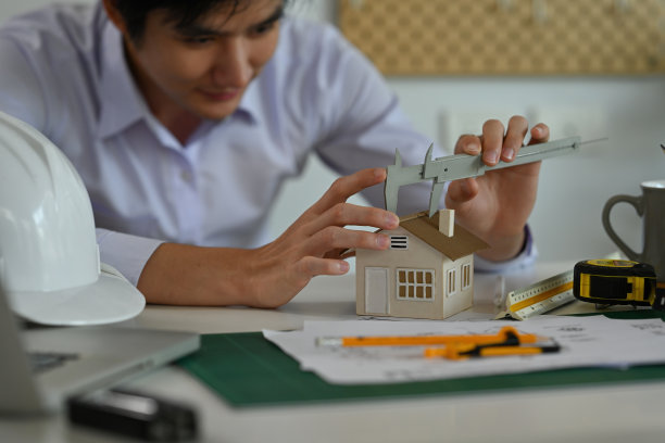 一幅建筑的肖像，一个房子模型，蓝图工具和机器在办公室的桌子上，为工程，建筑师，商业，安全和技术的概念。图片下载