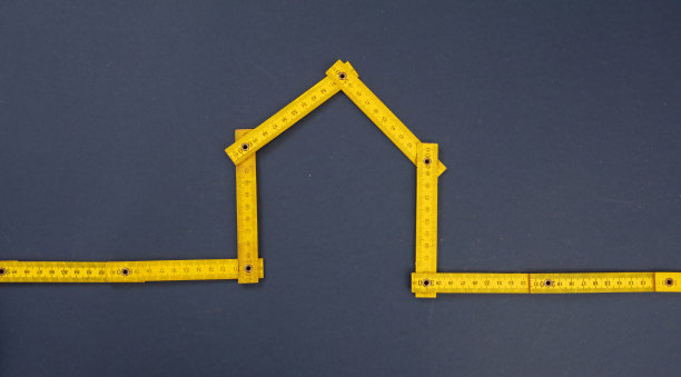 家居形状黄色木制测量在蓝色的背景。关闭视图。图片下载